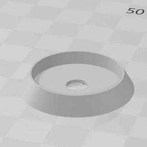 May include: A white plastic ring with a small hole in the centre. The ring is slightly raised on the outside edge.