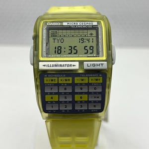 Può includere: Orologio digitale vintage Casio Micro Cosmos Telememo 50. Cassa e cinturino giallo trasparente. Il display mostra l'ora e la data. Include illuminazione e tastiera calcolatrice. Design retrò.