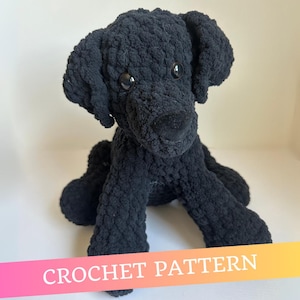 May include: A black crochet dog toy with a fluffy texture and large, dark eyes. The dog is seated, and the text "CROCHET PATTERN" is displayed across the bottom in a gradient of pink, orange, and yellow. A handmade item.