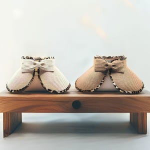 May include: Two sun hats with a bow detail. The hat on the left is white with a brown trim and the hat on the right is brown with a brown trim.
