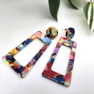 Op de afbeelding: Een paar kleurrijke rechthoekige oorbellen met een marmerpatroon. De oorbellen zijn gemaakt van acryl en hebben een gouden oorbel.