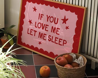 以下が含まれることがあります： 赤い星が付いた、赤い文字で「IF YOU LOVE ME LET ME SLEEP」と書かれたピンク色の額縁入りサイン。白いラジエーターに立てかけられています。リンゴの入ったバスケットと1つの桃が、赤と黒のタイルの床に置かれています。