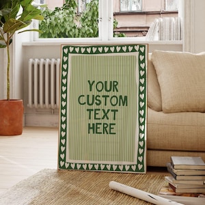 Puede incluir: Un tablero de letras de fieltro verde claro con borde blanco de corazón y triángulo. El tablero muestra el texto "YOUR CUSTOM TEXT HERE". El tablero está sobre una alfombra en una habitación con una ventana grande y una planta en maceta.