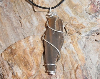 POWER OF TREES- features a beautiful piece of Petrified Wood that we found, cut and polished one one side then wrapped in silver.