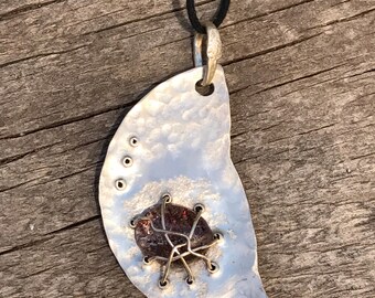 INVITATION... features a hammered silver free form shape with a cabochon of Lepidocrosite Included Quartz woven onto it.