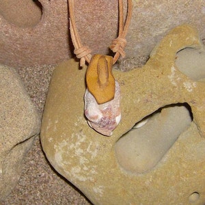 Movement This Amulet features a Water tumbled Shell fragment that has a Tan Leather bail image 1