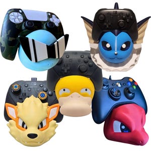 Peut inclure: Une collection d'accessoires de manette colorés, dont une manette à motif camouflage avec une boule bleue portant des lunettes de soleil, et plusieurs modèles sur le thème de personnages. Les accessoires sont conçus pour s'adapter aux manettes de jeu.