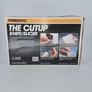 Könnte beinhalten: Eine Box für das "Cutup Knife/Slicer" von Presto. Die Box ist weiß, schwarz und orange und zeigt Bilder des Produkts in Aktion. Der Text beschreibt die Eigenschaften des Produkts, einschließlich seiner Fähigkeit, verschiedene Lebensmittel zu schneiden, und seine einfache Reinigung.