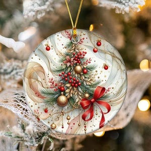 Puede incluir: Adorno navideño redondo con un diseño festivo. El adorno presenta un árbol de Navidad estilo acuarela con bayas rojas, adornos dorados y un lazo rojo. El fondo tiene un patrón arremolinado en tonos neutros, y el adorno cuelga de una cuerda dorada.