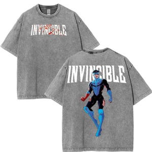 May include: Gray t-shirt with the word "INVINCIBLE" printed on the front and a superhero character printed on the back.