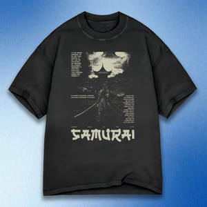 May include: Black t-shirt featuring a graphic of a samurai warrior with a sword, a pagoda, and text. The text reads "Based on the Samurai" in a stylized font. Additional text is present above and to the sides of the samurai.