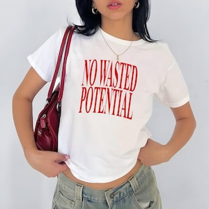 May include: White t-shirt with red text that reads "NO WASTED POTENTIAL".