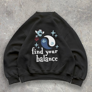 Może przedstawiać: Biały ceramiczny kubek z czarnym uchwytem i napisem "But First, Coffee" czarną, pogrubioną czcionką. Kubek stoi na białej powierzchni.