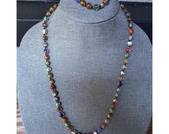 May include: A colorful beaded necklace and bracelet set with gold accents. The beads are made of glass and have a variety of colors and patterns.