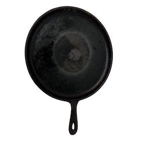 May include: A black cast iron skillet with a long handle. The skillet is seasoned and has a dark, almost black, patina.