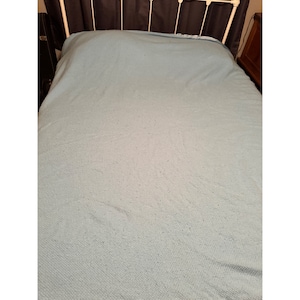 May include: A light blue bedspread with a textured surface.