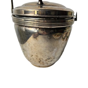 May include: Silver ice bucket with a lid and a handle. The bucket has a slightly rounded shape and a shiny finish.