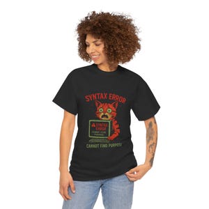 May include: Black t-shirt with a red and orange cat illustration on a computer screen. The text on the screen reads "Syntax Error Cannot Find Purpose". The text below the image reads "Syntax Error Cannot Find Purpose".