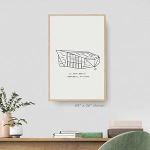 Pode incluir: Um desenho a preto e branco do U.S. Bank Stadium em Minneapolis, Minnesota. O desenho está sobre um fundo branco com uma moldura de madeira. O texto "U.S. Bank Stadium Minneapolis, Minnesota" está abaixo do desenho. O texto "24" x 36" shown" está abaixo da moldura.