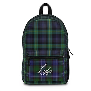 May include: A backpack with a black top handle and a front pocket. The backpack features a green, blue, and yellow plaid pattern. The name "Luke" is written in white cursive on the front pocket. A black zipper and a side mesh pocket are also visible.