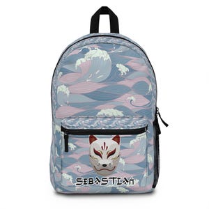May include: A backpack with a Japanese wave pattern in shades of blue and pink. The front pocket features a white and red Kitsune mask design, with the name "SEBASTIAN" printed below in Japanese characters. The backpack has a black handle and zipper.