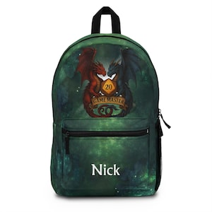 May include: Green backpack featuring a fantasy design with two dragons facing each other, a die with the number 20, and the text "GAME MASTER". The backpack also has the name "Nick" printed on it.