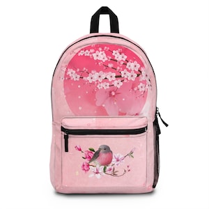May include: Pink backpack featuring a bird perched on a flowering branch, with a large pink circle and cherry blossom branches on the front. The backpack has a black top handle, black zippers, and a side mesh pocket. The design is a floral and nature-themed.