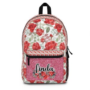 May include: A floral backpack featuring a red rose pattern on a white background. The front pocket is a glittery pink with the name "Linda" in cursive script. The backpack has a black handle and zipper.