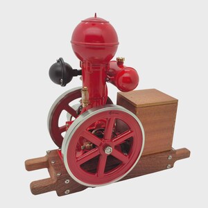 May include: A red model engine with a round top, two red wheels, and a wooden base. The engine has silver accents and a black component on the side. The wooden base and box are a natural wood color.