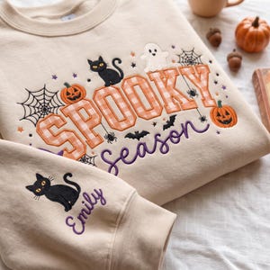 Halloween-Sweatshirt mit Applikationen, orange-weiß karierter Rundhalsausschnitt, bestickter Pullover mit schwarzer Katze, Kürbis-Geister-Shirt, individuell gestaltbare Ärmel