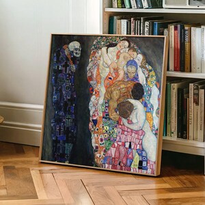 Peut inclure: Une impression d'art carrée encadrée représentant La Mort et la Vie de Gustav Klimt. Le côté gauche montre un squelette dans une robe bleu foncé à motifs de croix, tandis que le côté droit présente un groupe de personnages colorés enlacés.