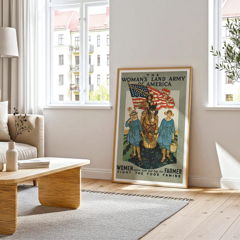 May include: A framed vintage poster with a patriotic theme. The poster features an illustration of women and a horse with an American flag, with text that reads "The Woman's Land Army of America" and "Women enlist now and help the farmer fight the food famine."