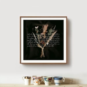 May include: A framed print featuring a dried flower bouquet against a dark background. The bouquet includes various dried flowers and greenery, tied together with twine. Handwritten script is overlaid on the dark background. The frame is a dark brown color.