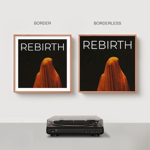 May include: Two framed art prints with the word "REBIRTH" in white text on a black background. The prints feature an orange draped figure. A black turntable is in the foreground.