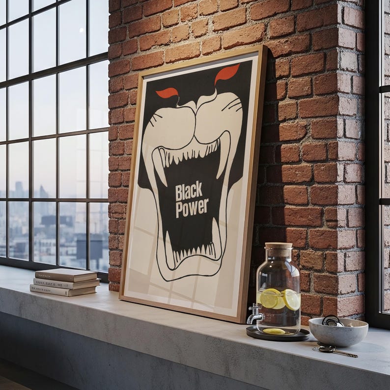 May include: A framed poster with a black and white illustration of a roaring panther with the words "Black Power". The poster is leaning against a brick wall near a window. A glass water dispenser with lemon slices is also visible.