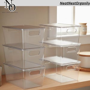 May include: Clear plastic storage bins with lids and integrated handles. The bins are stacked on a wooden surface, with some arranged in a group of three and others in a group of two. The brand name "NeatNestOrganily" is visible in the image.