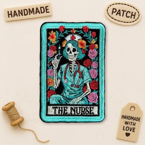 May include: Embroidered patch featuring a skeleton nurse holding a syringe, surrounded by flowers. The patch has a teal border and the words "THE NURSE" at the bottom. The patch is rectangular and has a black background. The word "HANDMADE" is on a wooden tag.