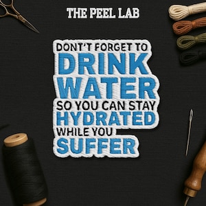 May include: An embroidered patch with the text "DON'T FORGET TO DRINK WATER SO YOU CAN STAY HYDRATED WHILE YOU SUFFER" in blue and white. The image also includes spools of thread, scissors, and a needle.