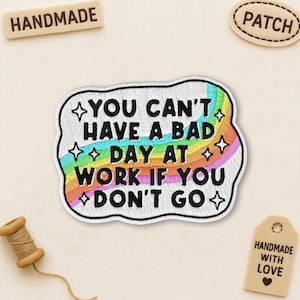 May include: Embroidered patch with the text "YOU CAN'T HAVE A BAD DAY AT WORK IF YOU DON'T GO" in black, white, and rainbow colors. The patch has a white border and a whimsical design. Additional tags read "HANDMADE" and "PATCH".