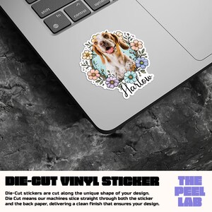 May include: A die-cut vinyl sticker featuring a smiling dog with brown and white fur, surrounded by colorful flowers. The dog's name, "Harlow," is written in cursive. The sticker is on a laptop, with the text "DIE-CUT VINYL STICKER" visible.