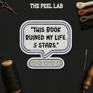 May include: An embroidered patch with the text "THIS BOOK RUINED MY LIFE. 5 STARS." in a speech bubble design. The patch features a light blue border and five gold stars. The Peel Lab logo is at the top.