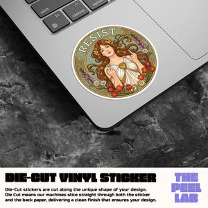 May include: A die-cut vinyl sticker featuring a woman with long brown hair, floral crown, and the word "RESIST". The sticker has a green border with flowers and is on a laptop. The sticker is from The Peel Lab.