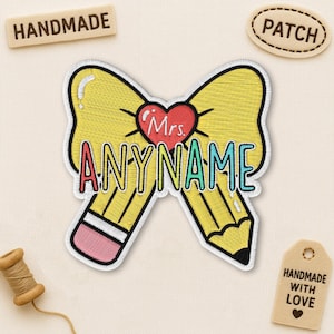 Peut inclure: Écusson brodé avec un motif de crayon jaune et le texte "ANYNAME" en turquoise et rouge. Un cœur rouge avec "Mrs." est au-dessus du texte. Les mots "HANDMADE" et "PATCH" entourent l'écusson.