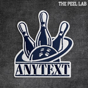 May include: Embroidered patch featuring a bowling ball and pins in navy blue and white. The design includes the text "ANYTEXT" in a rectangular frame. The patch is set against a textured gray background, with the text "THE PEEL LAB" at the top.