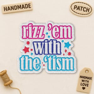 Peut inclure: Écusson brodé avec la phrase "rizz 'em with the 'ism" en rose, bleu et blanc. L'écusson est entouré de petits accents d'étoiles. Des étiquettes supplémentaires indiquent "fait à la main" et "écusson".