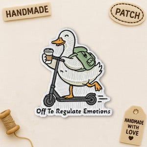 Peut inclure: Écusson brodé représentant une oie blanche sur un scooter, tenant un café et portant un sac à dos vert. Le texte "Off To Regulate Emotions" est présent. Comprend des étiquettes "Handmade" et "Patch".