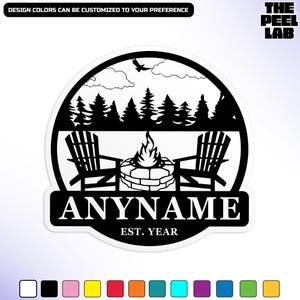 May include: A black and white sticker depicting a campfire scene with two Adirondack chairs, a fire pit, and trees. The text "ANYNAME" is displayed below the scene, with "EST. YEAR" underneath. The text "DESIGN COLORS CAN BE CUSTOMIZED TO YOUR PREFERENCE" is at the top.