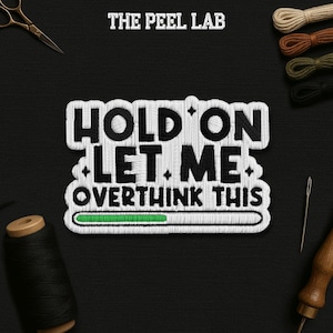 May include: Embroidered patch with the text "HOLD ON LET ME OVERTHINK THIS" in white thread on a black background. A green progress bar is at the bottom. The Peel Lab logo is at the top.