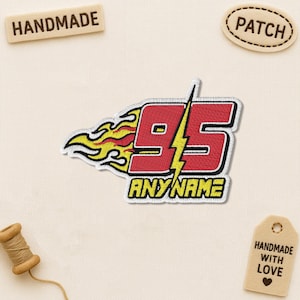 May include: Embroidered patch featuring the number 95 in red with a yellow lightning bolt and flames. The text "ANY NAME" is below the number. The patch is white-bordered and suitable for customization. Handmade patch.
