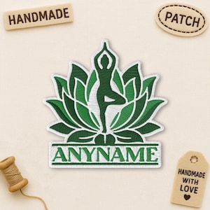May include: Embroidered patch featuring a green yoga pose silhouette within a lotus flower design. The patch includes the text "ANYNAME" at the bottom. Additional tags read "HANDMADE" and "PATCH". A spool of thread and a tag that says "HANDMADE WITH LOVE" are also present.